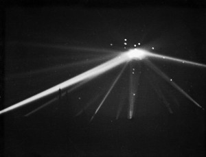 Searchlights converge on an unidentified object over Los Angeles in the early morning hours. White dots are ammunitions.