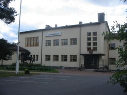 Marttilan kunnantalo. Rakennuksen edustalla on Arto Ali-Eskolan kunnan vaakunaan perustuva veistos.
