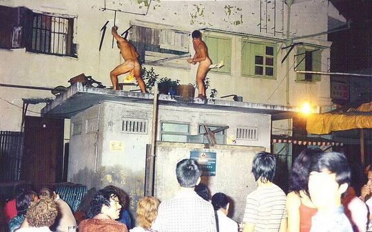 Western servicemen called "flamers" dancing stark naked above the public toilet on Corps Day, 1969.