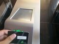 A Schindler PORT access card being tapped on a PORT terminal in a security gate.