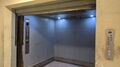 Interior of a 1970s Hitachi freight elevator, with vertical two speed telescoping doors.